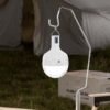 LED camping lantern 7853 with metal hook hanging outdoors for tent lighting.